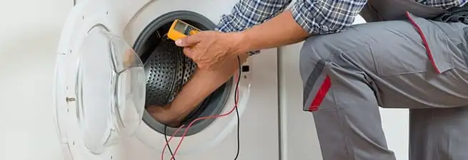 Dryer repair technician inspecting and repairing a clothes dryer in Sacramento, CA