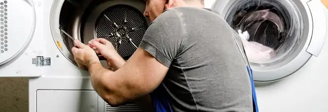 Dryer repair technician fixing a clothes dryer drum in Sacramento, CA