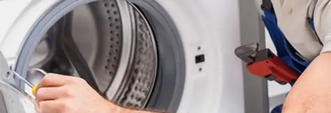 Appliance technician repairing a clothes dryer drum and internal parts in Sacramento, CA