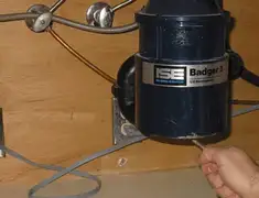 Garbage disposal repair technician tightening the mounting ring under a sink in Sacramento, CA