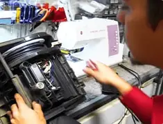 Vacuum repair technician servicing internal components on a workbench in Sacramento, CA