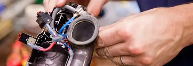 Vacuum repair technician reconnecting wiring and components in Sacramento, CA