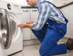 Washing machine repair technician servicing a front-load washer in Sacramento, CA