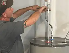 Water heater repair technician tightening supply line connections in Sacramento, CA
