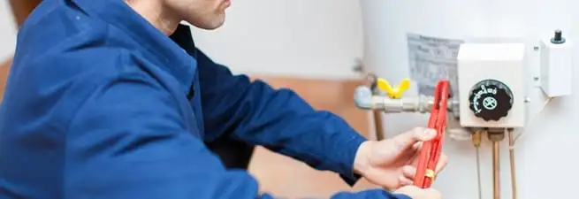 Water heater repair technician adjusting the temperature control and gas valve in Sacramento, CA